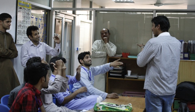 Instructor Waleed Hashmi and his participants communicating with each other through sign language during the workshop