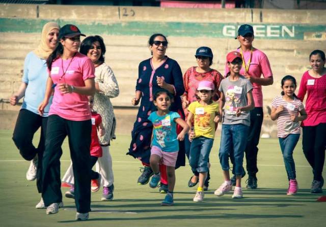 Mothers and daughters practice with the coach at the “Mommy and Me” football clinic