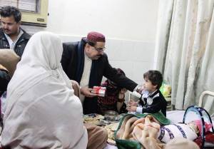 Balochistan Food and Women Development Minister Mir Izhar Hussain Khosa presenting gifts prepared by PUAN Balochistan chapter to a child at the Civil Hospital Quetta on Day One of Cultural Diversity Expo on Thursday, 26 December 2013. 